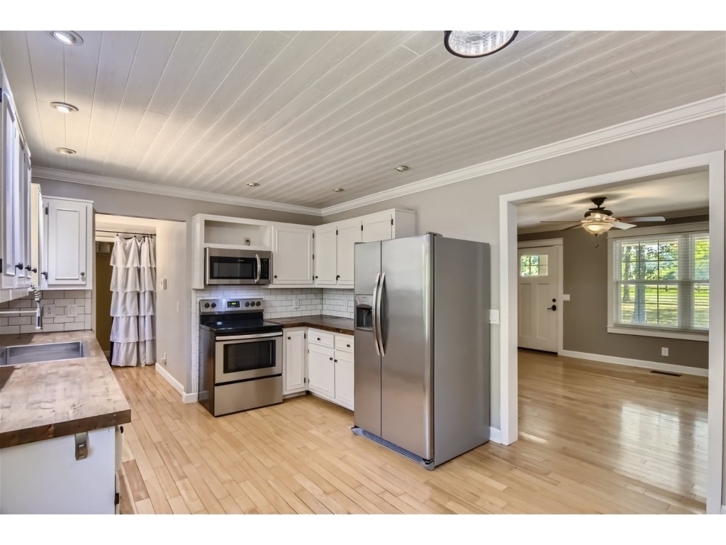 6824 Beckwith Road Mount Juliet, TN 37122 - Photo 5 of 36 a kitchen with stainless steel appliances granite countertop a refrigerator a stove a sink dishwasher and white cabinets with wooden floor