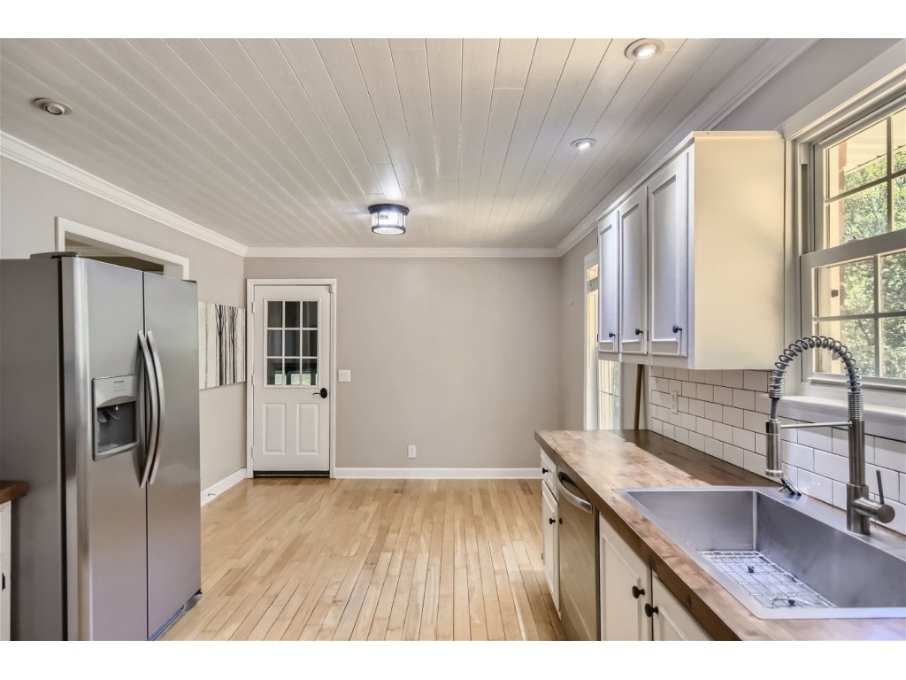 6824 Beckwith Road Mount Juliet, TN 37122 - Photo 7 of 36 a kitchen with stainless steel appliances granite countertop a refrigerator a sink and white cabinets with wooden floor