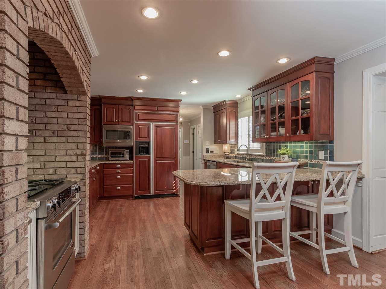 1003 Queensferry Road Cary, NC 27511 - Photo 8 of 30 Gorgeous kitchen with cherry cabinets and a unique hearth.