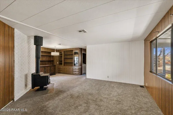 an empty room with closet and windows