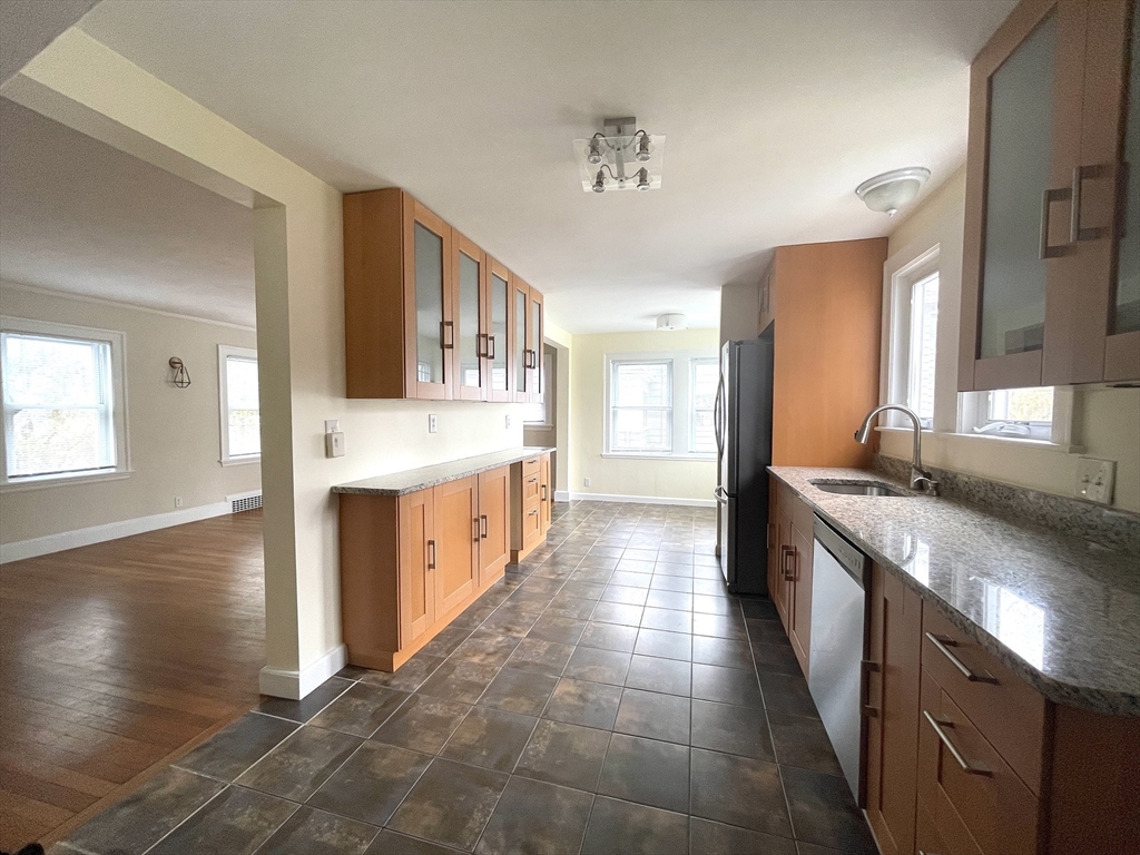 a large kitchen with stainless steel appliances granite countertop a stove and a sink