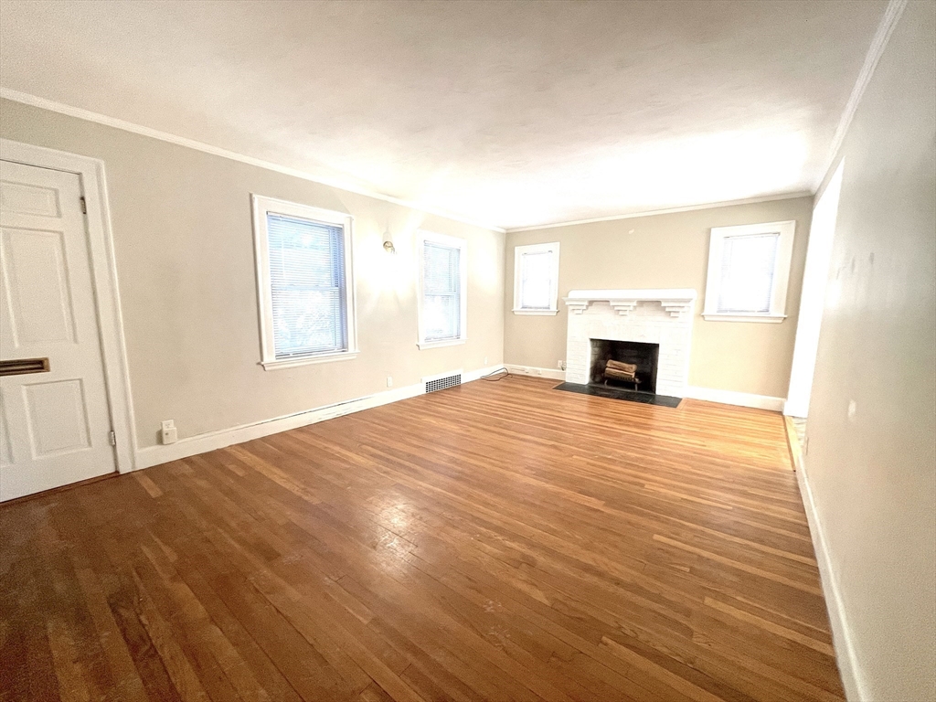 76 Cloverdale Road, Unit 76 Newton, MA 02461 - Photo 4 of 10 a view of empty room with wooden floor and fireplace