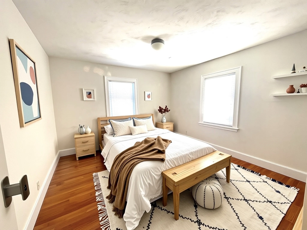 76 Cloverdale Road, Unit 76 Newton, MA 02461 - Photo 4 of 9 a bedroom with a bed and wooden floor