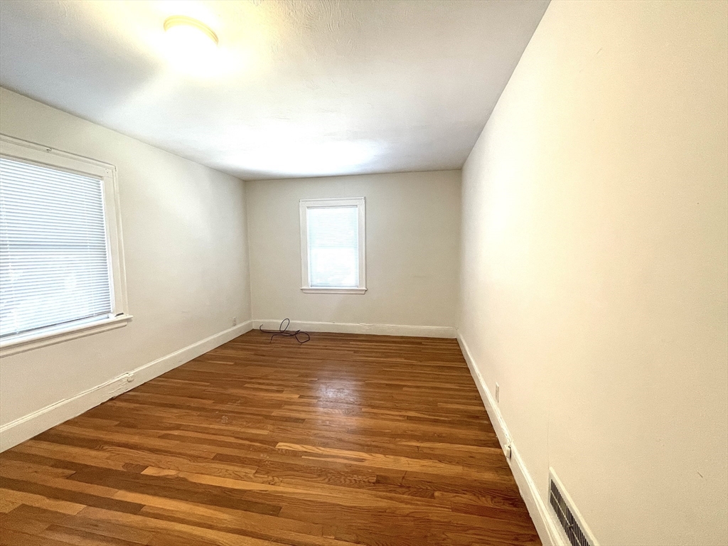76 Cloverdale Road, Unit 76 Newton, MA 02461 - Photo 5 of 10 a view of an empty room with wooden floor and a window