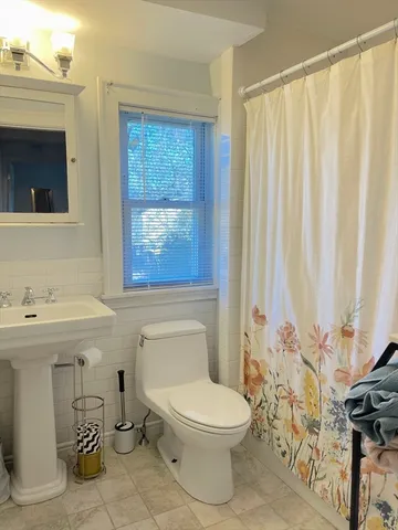 a bathroom with a toilet a sink and a mirror