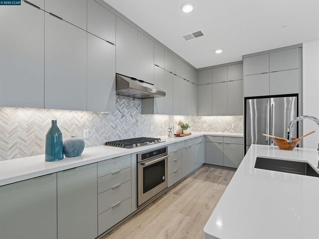 a kitchen that has a lot of cabinets in it and wooden floors