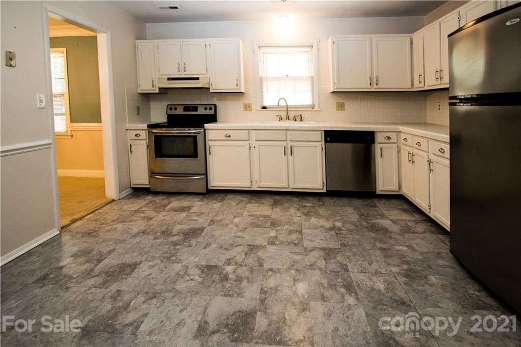 412 Neill Ridge Road Matthews, NC 28105 - Photo 4 of 25 a kitchen with stainless steel appliances granite countertop a stove a sink and a refrigerator