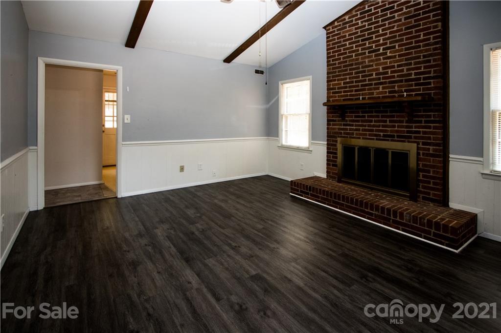 412 Neill Ridge Road Matthews, NC 28105 - Photo 7 of 25 a view of an empty room with wooden floor a fireplace and windows