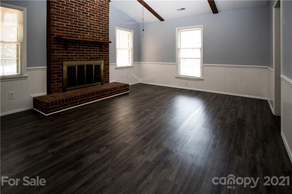 412 Neill Ridge Road Matthews, NC 28105 - Photo 8 of 25 an empty room with wooden floor a fireplace and windows