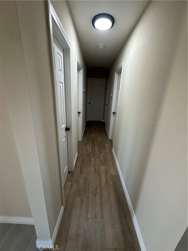 22661 Fisher Street Perris, CA 92570 - Photo 5 of 10 en view of a hallway with wooden floor and staircase