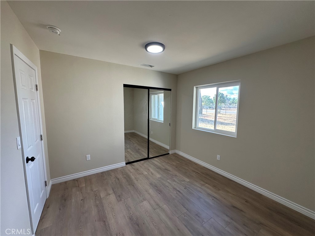 22661 Fisher Street Perris, CA 92570 - Photo 6 of 10 an empty room with wooden floor and windows