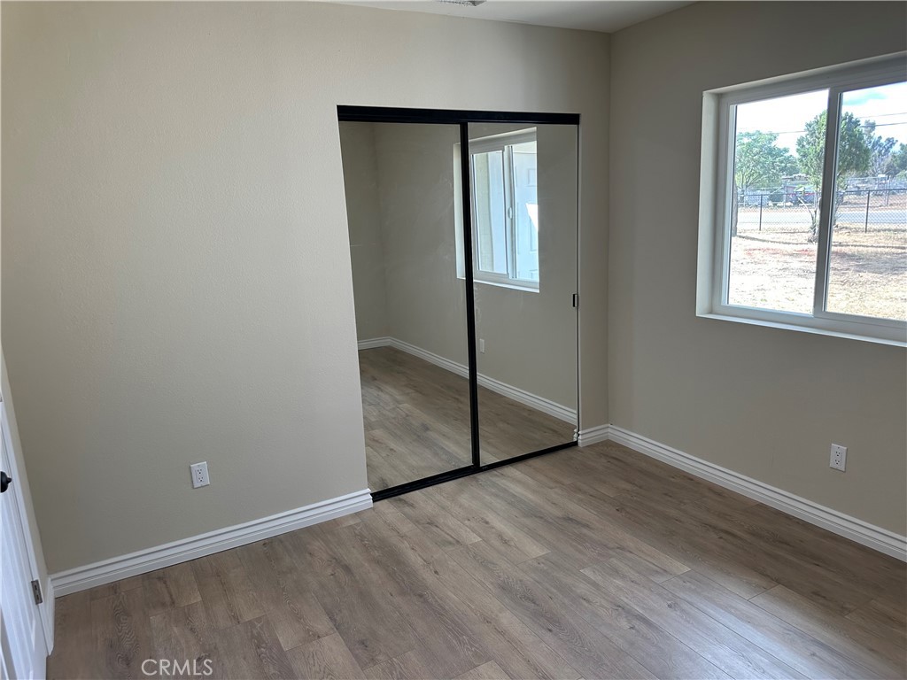 22661 Fisher Street Perris, CA 92570 - Photo 7 of 10 an empty room with wooden floor and windows