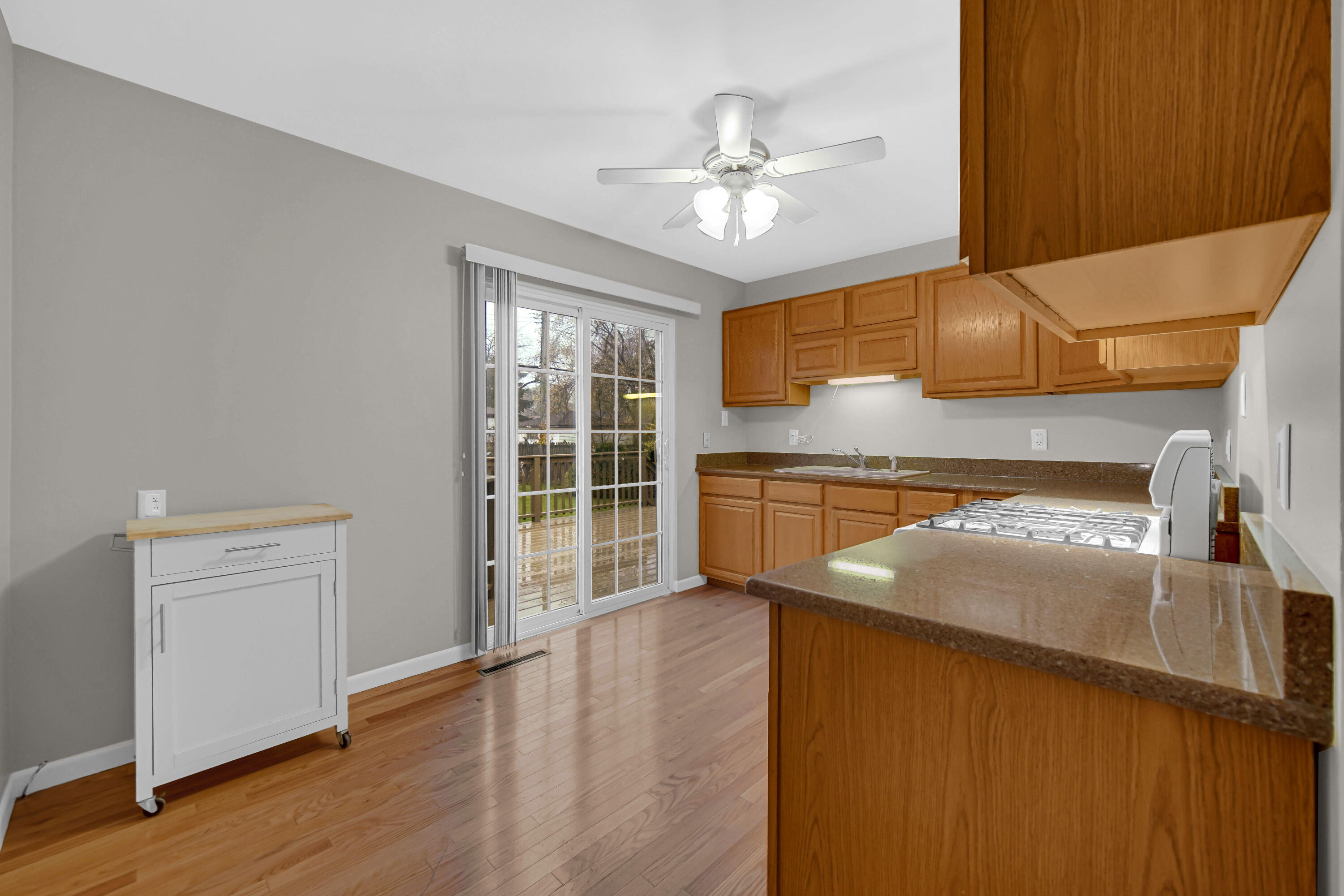 3302 Eder Street Highland, IN 46322 - Photo 6 of 19 a kitchen with kitchen island granite countertop wooden cabinets and white appliances