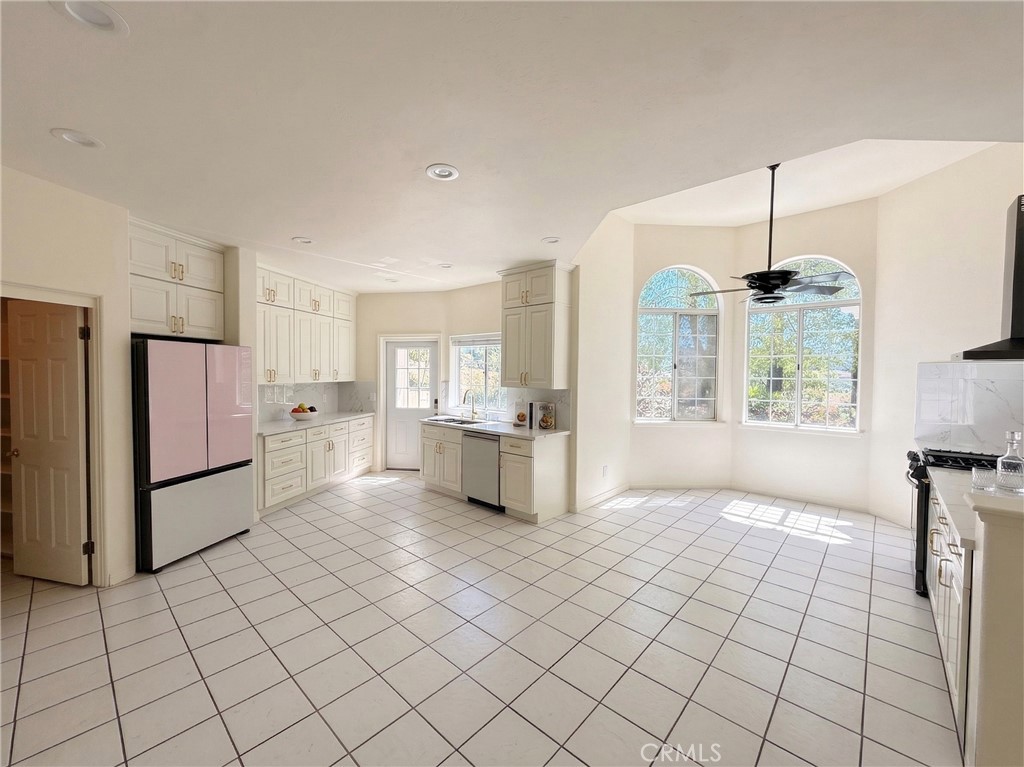 39850 Kapalua Way Temecula, CA 92592 - Photo 11 of 35 a kitchen with stainless steel appliances kitchen island granite countertop a refrigerator a stove and white cabinets with wooden floor