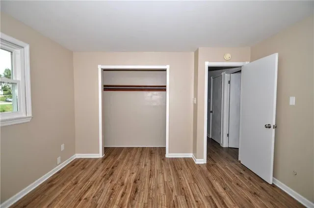 a view of a room with wooden floor staircase and a hallway