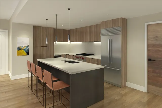 a kitchen with a refrigerator a sink and chairs