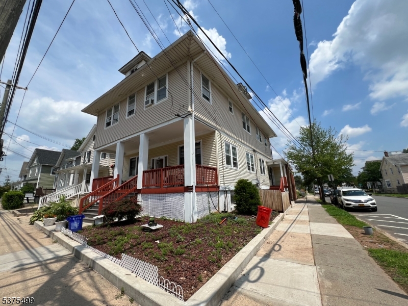a view of a white house with a small yard and sitting area