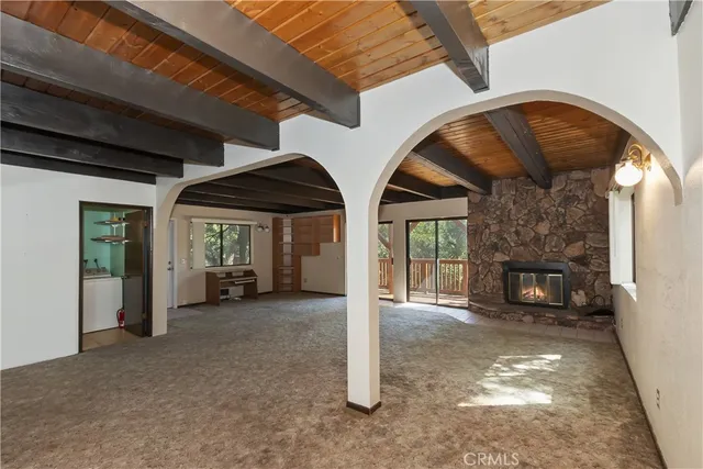 a view of an empty room with a fireplace and a window