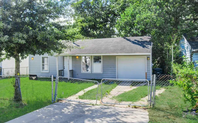 front view of a house with a yard and a large tree