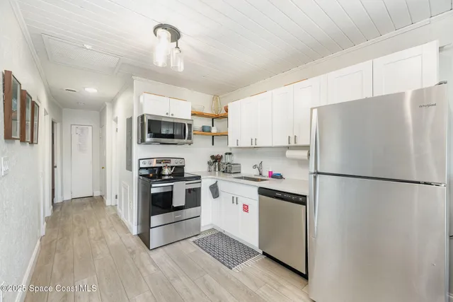 a kitchen with stainless steel appliances a refrigerator sink and microwave