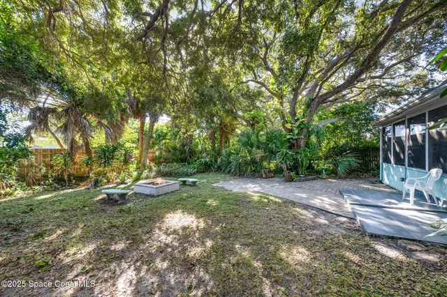 a view of a backyard with table and chairs under an umbrella