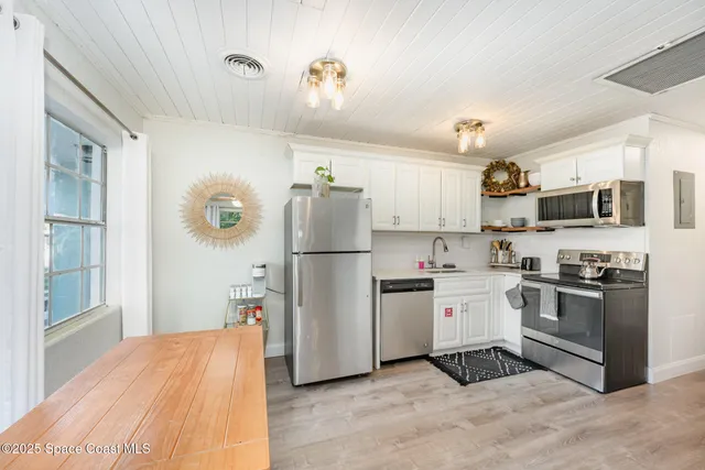 a kitchen with stainless steel appliances granite countertop a refrigerator stove microwave and sink