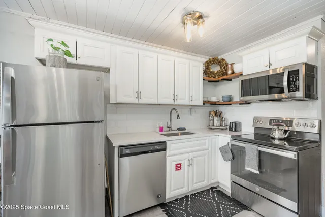 a kitchen with stainless steel appliances a refrigerator sink and microwave
