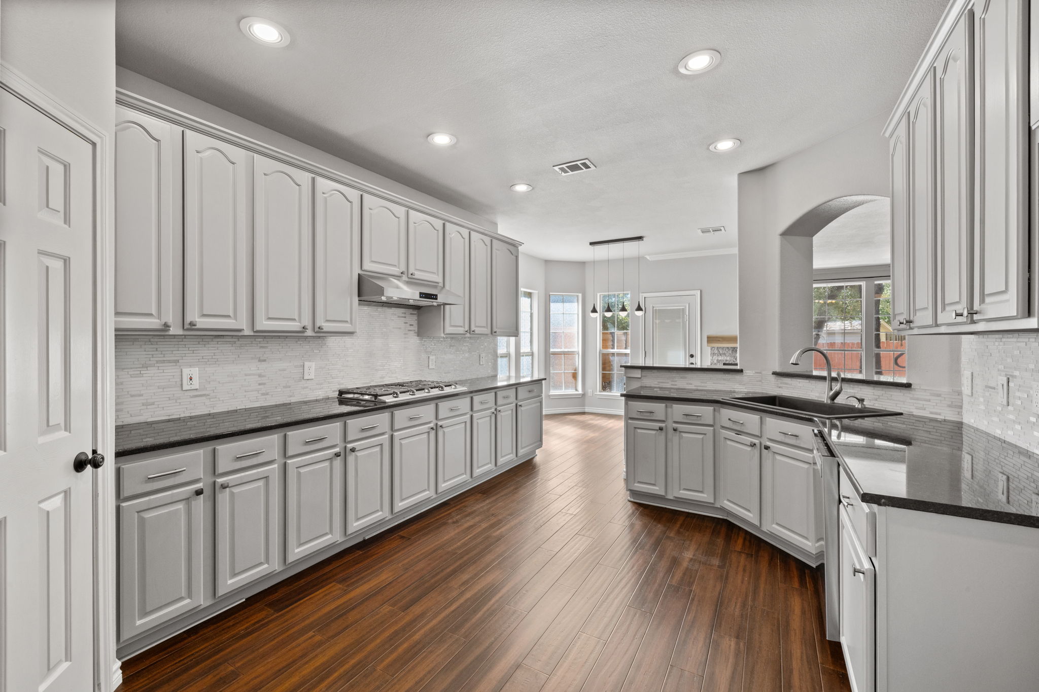 2211 Spring Hollow Path Round Rock, TX 78681 - Photo 8 of 36 Gleaming hardwood bamboo floors complement expansive cabinetry and modern solid surface countertops in this open kitchen.