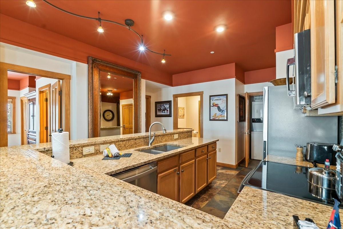 91 River Run Road, Unit 8111 Keystone, CO 80435 - Photo 7 of 43 a large kitchen with stainless steel appliances kitchen island granite countertop a sink and cabinets