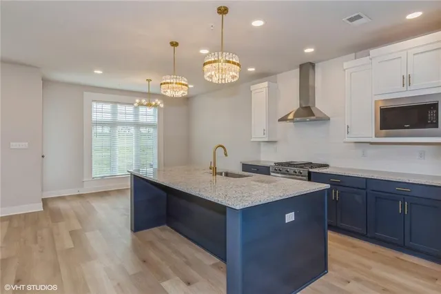 a kitchen with cabinets a center island and stainless steel appliances
