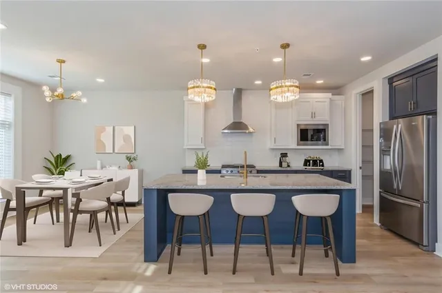 a kitchen with kitchen island granite countertop a sink and a refrigerator