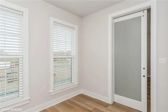 a view of a small space with wooden floor and a window