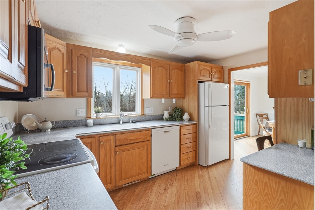 1032 Main Street, Unit 6 Millis, MA 02054 - Photo 11 of 42 a kitchen with stainless steel appliances granite countertop a refrigerator a sink dishwasher a stove with wooden cabinets and floor
