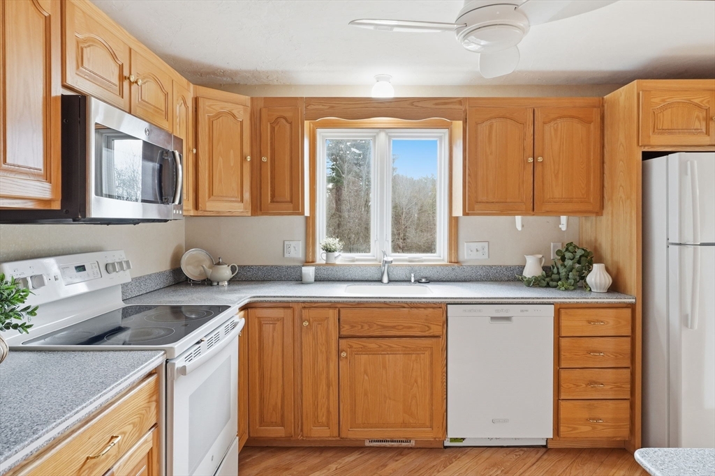 1032 Main Street, Unit 6 Millis, MA 02054 - Photo 12 of 42 a kitchen with stainless steel appliances granite countertop a sink and a refrigerator