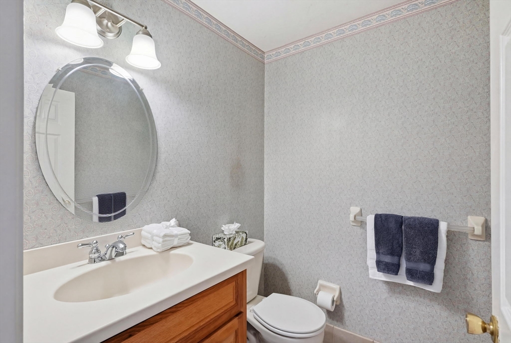 1032 Main Street, Unit 6 Millis, MA 02054 - Photo 15 of 42 a bathroom with a toilet a sink and mirror