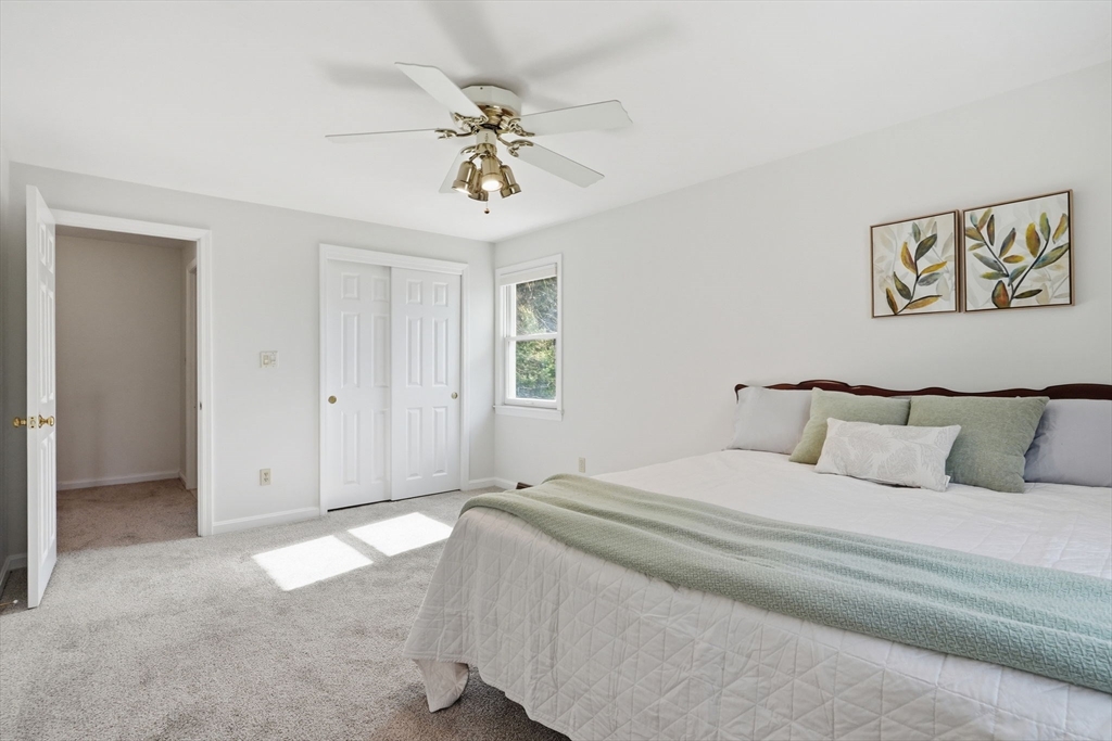 1032 Main Street, Unit 6 Millis, MA 02054 - Photo 17 of 42 a spacious bedroom with a bed and a chandelier