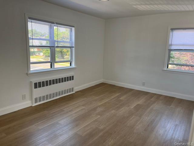 46-05 158th Street Queens, NY 11358 - Photo 12 of 15 a view of an empty room with wooden floor and a window