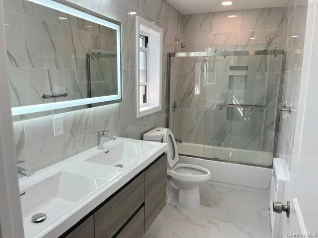 a bathroom with a sink a toilet and shower