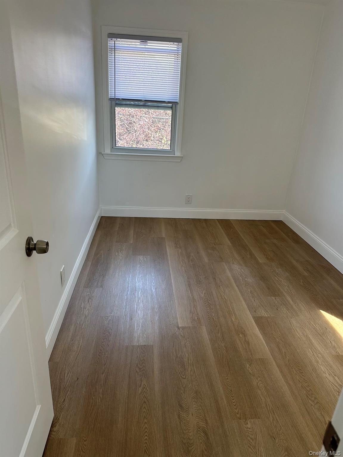 46-05 158th Street Queens, NY 11358 - Photo 4 of 15 an empty room with wooden floor and windows