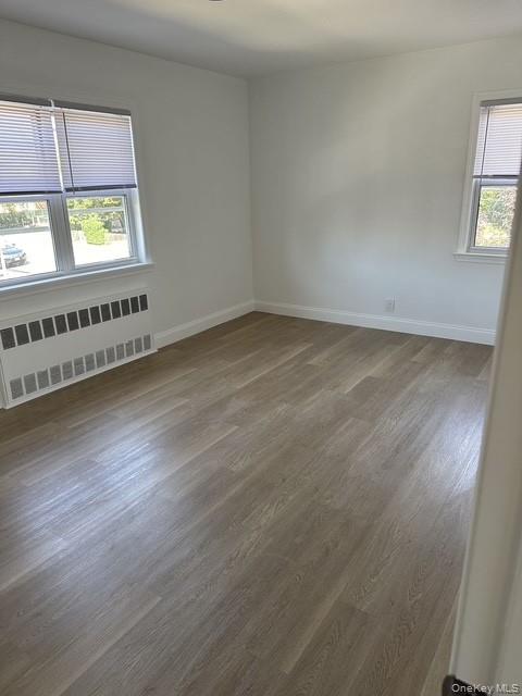 46-05 158th Street Queens, NY 11358 - Photo 5 of 15 an empty room with wooden floor and windows