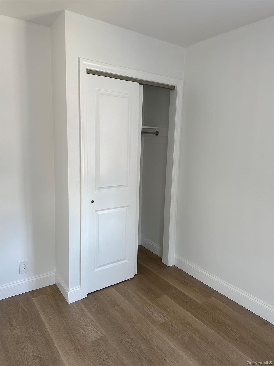 46-05 158th Street Queens, NY 11358 - Photo 6 of 15 an empty room with wooden floor and closet area