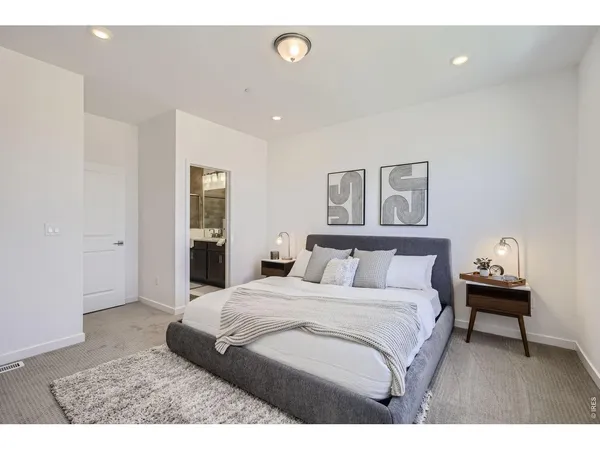 a bedroom with a bed and a painting on the wall