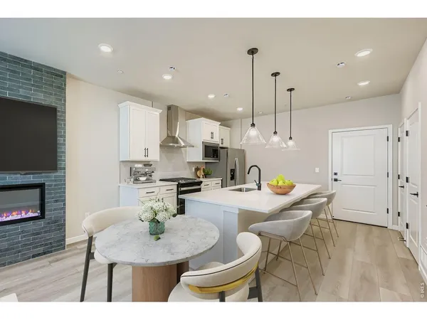 a kitchen with stainless steel appliances kitchen island granite countertop a stove a kitchen island a dining table and chairs