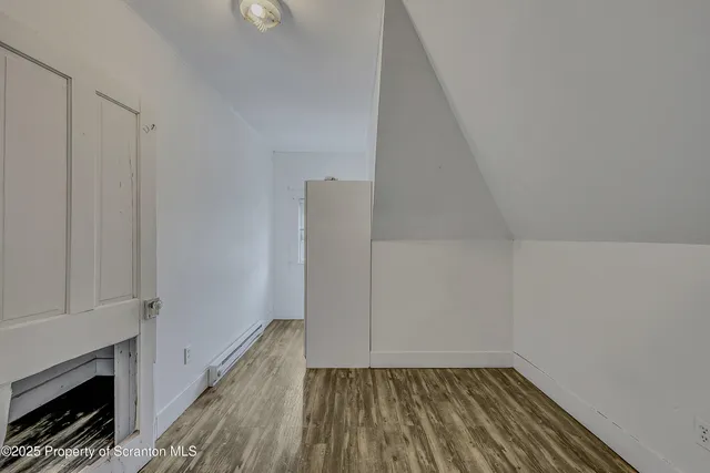 a view of a hallway with wooden floor and a fireplace