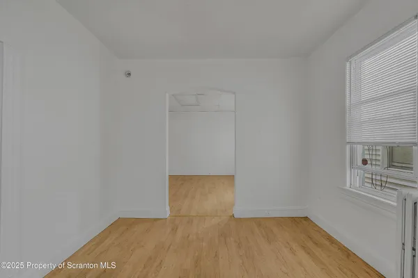 a view of empty room with wooden floor and cabinet