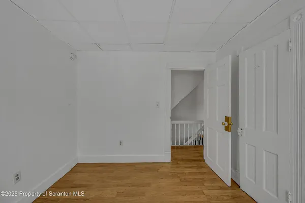 a view of a hallway with wooden floor and entryway
