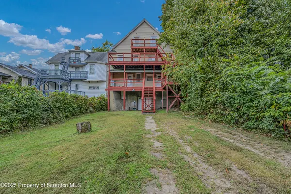 a view of a house with backyard and trees