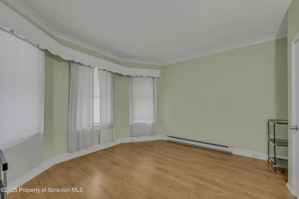 a view of empty room with wooden floor
