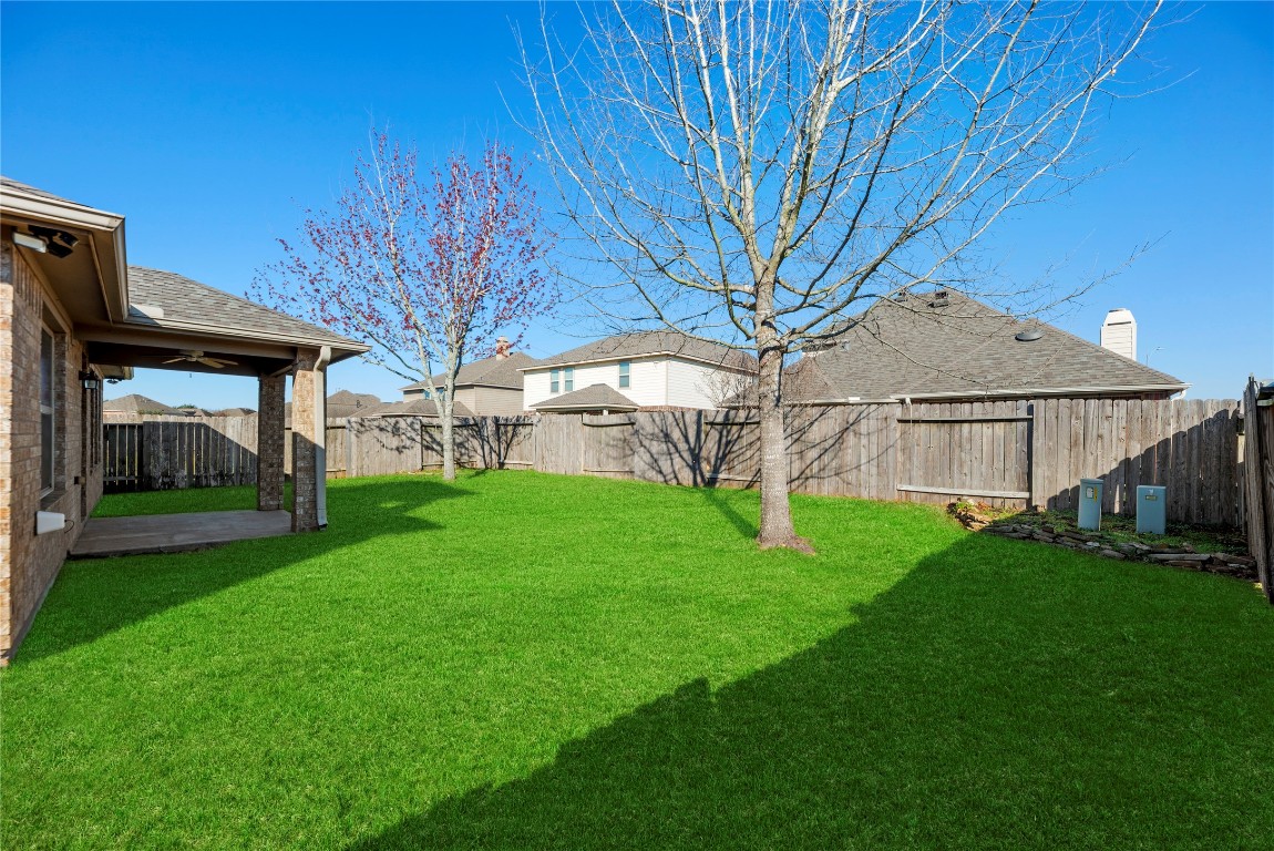 3311 Sabine Spring Lane Katy, TX 77449 - Photo 12 of 16 Step outside to a fully fenced backyard featuring a professional sprinkler system and a covered patio area. This expansive green space is perfect for outdoor activities and quiet evenings in Waterstone.