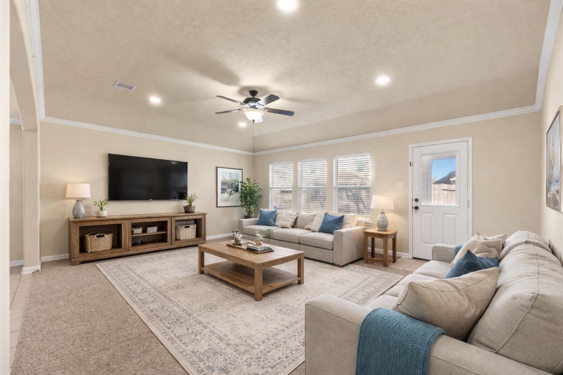 3311 Sabine Spring Lane Katy, TX 77449 - Photo 3 of 16 The spacious living area serves as a central hub for relaxation, highlighted by fresh carpet and a modern ceiling fan. Large windows fill the room with an airy atmosphere. Virtually staged so you can imagine the possibilities.